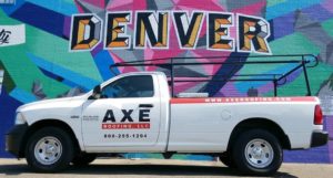 A white Axe Roofing branded truck in front of a colorful mural that reads "DENVER"